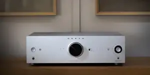 Silver Onkyo Icon A-50 integrated amplifier on an oak cabinet, with black volume dial and orange indicator